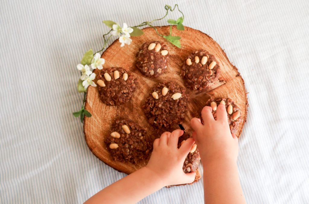 mãos de crianças roubando os cookies da mesa.